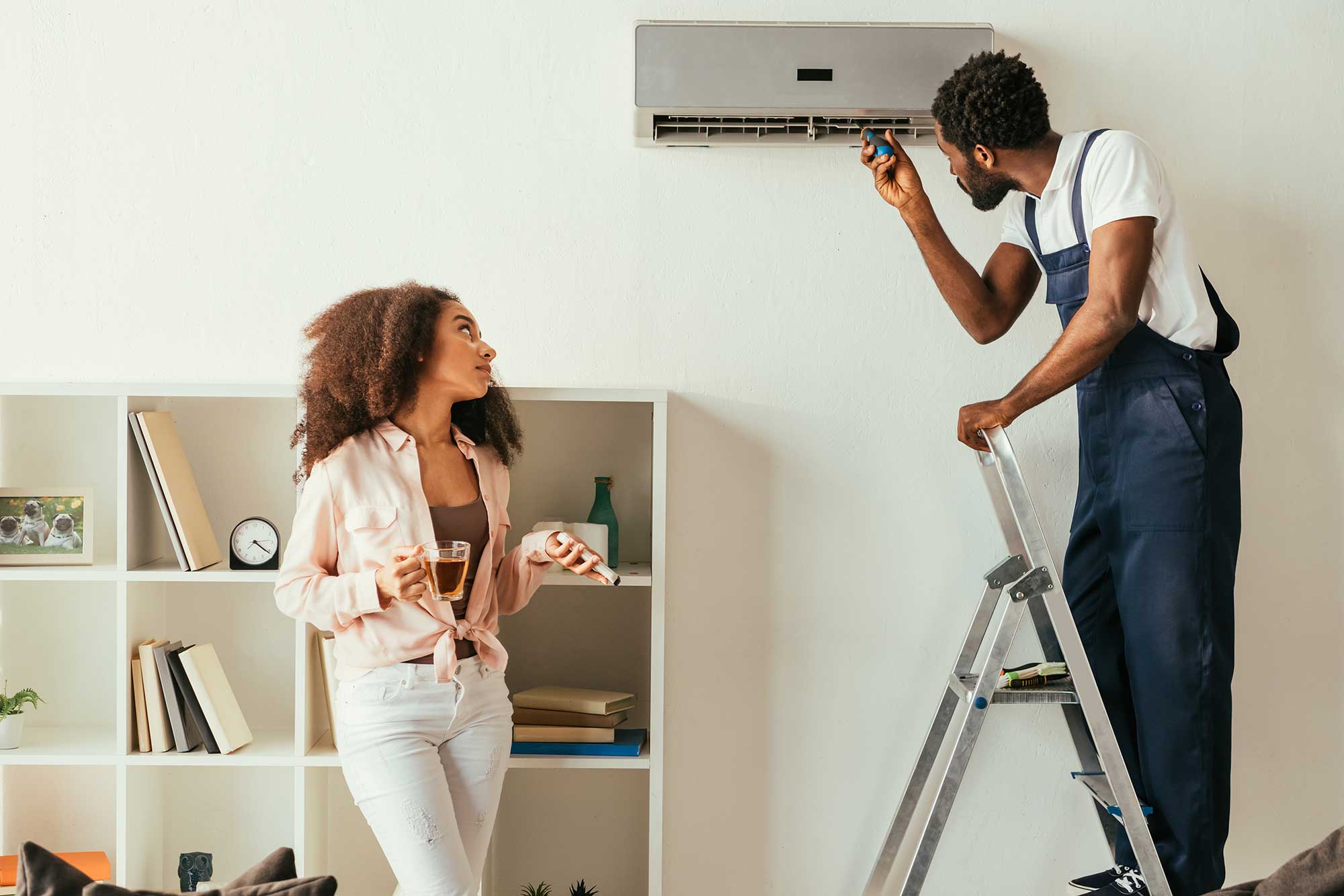 african-american-repairman-fixing-air-conditioner-2022-12-16-16-20-43-utc
